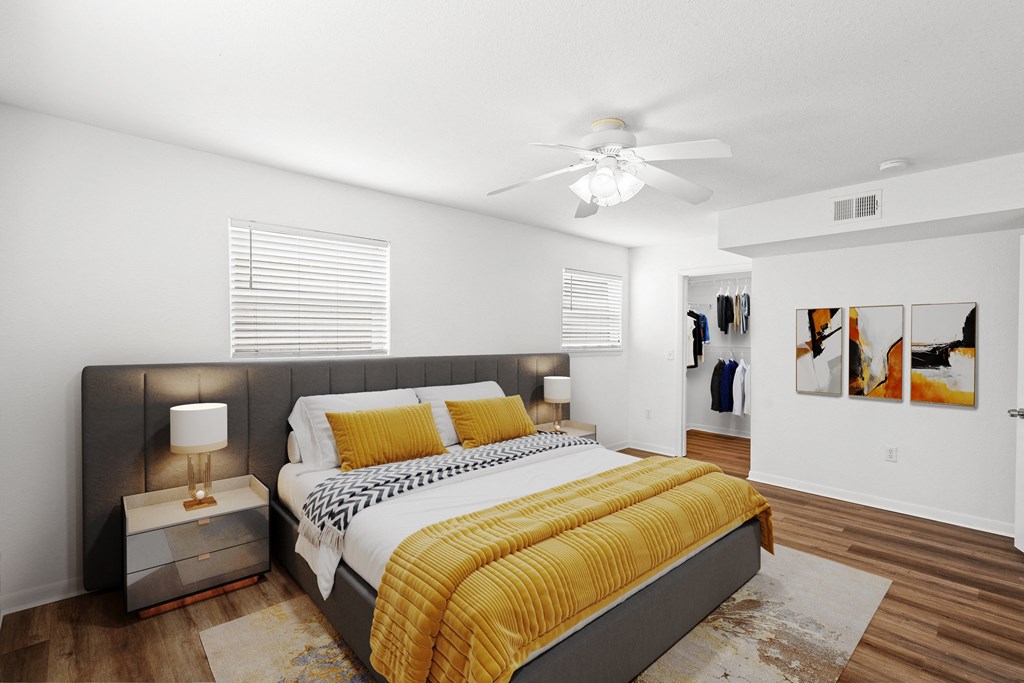 A bedroom with windows, a ceiling fan, and a walk in bedroom closet at Malvern Hill Apartment Homes, 66103, KS
