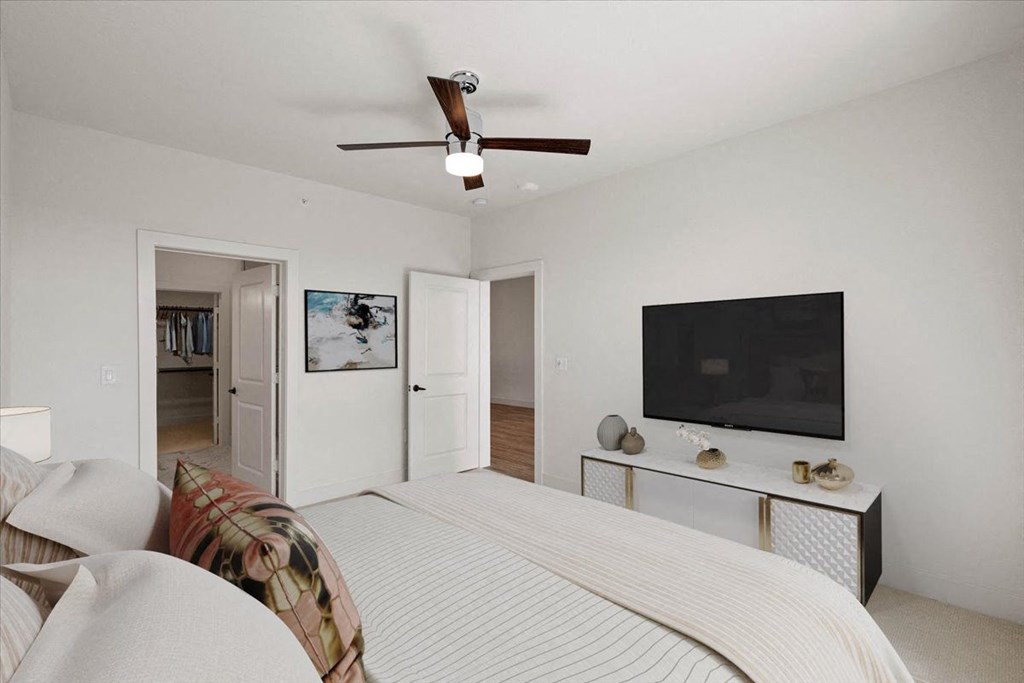 a bedroom with a bed and a ceiling fan