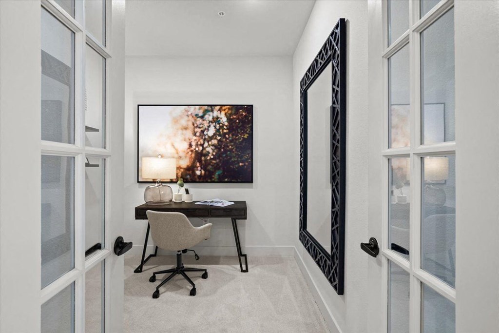 a home office with a desk and a large picture on the wall