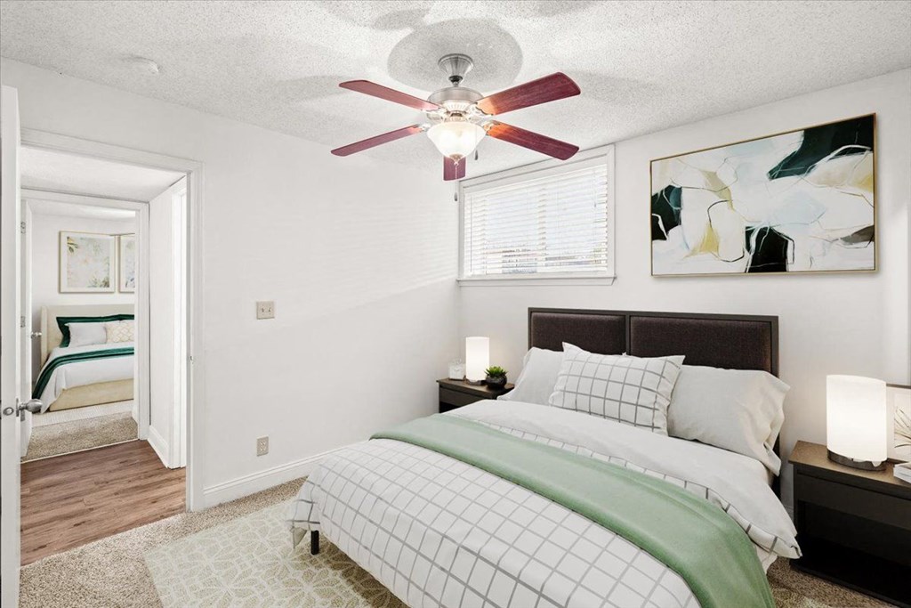a bedroom with a bed and a ceiling fan