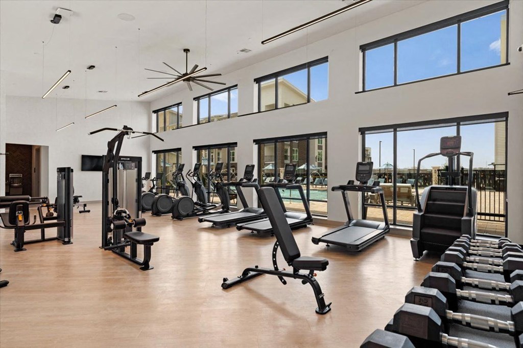 the gym has a view of the pool and gym equipment