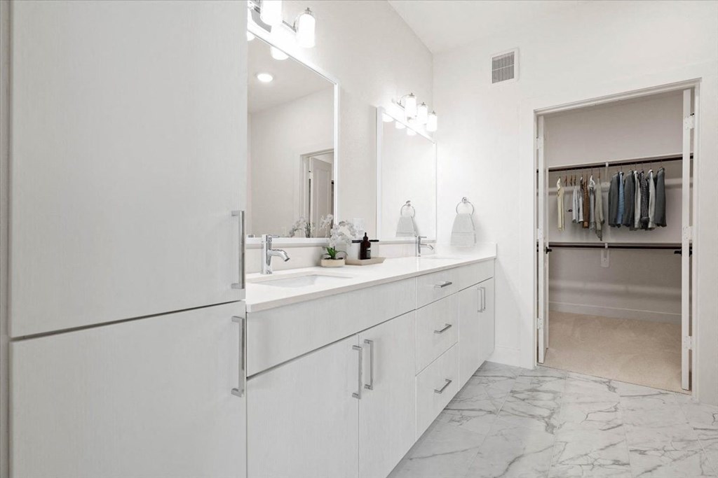 a white bathroom with a sink and a refrigerator