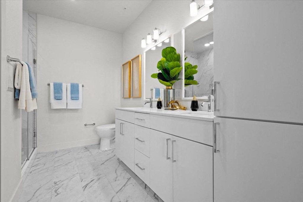 a white bathroom with a sink and a refrigerator