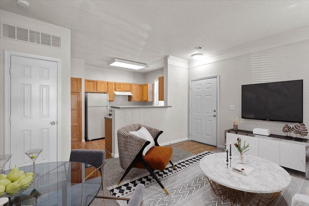 A modern living room with a glass table and a television. at Somerset Oaks Apartment Homes, Kansas
