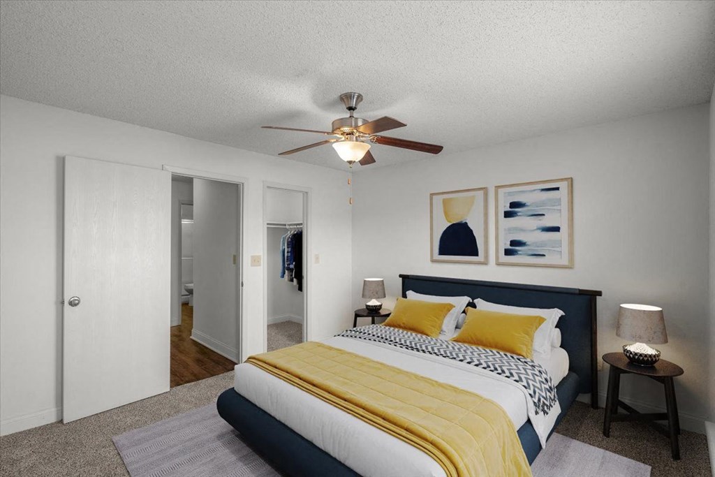a bedroom with a bed and a ceiling fan at Cloverset Active Adult Apartments, Kansas City, MO