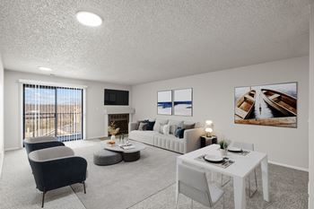 A living room with a grey sofa, a white coffee table, and a fireplace.