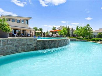 a large swimming pool with a building in the background
