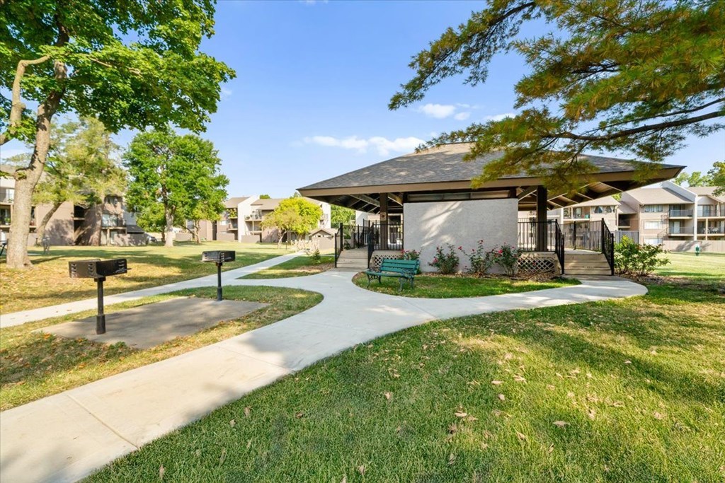 A park with a walking path and a pavilion.