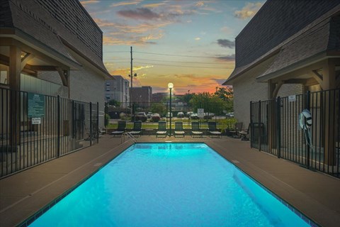 A swimming pool surrounded by a fence and buildings.