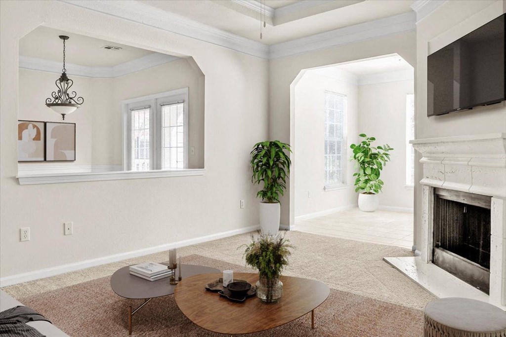 a living room with a fireplace and a table at Wynnewood Farms Apartments, Overland Park