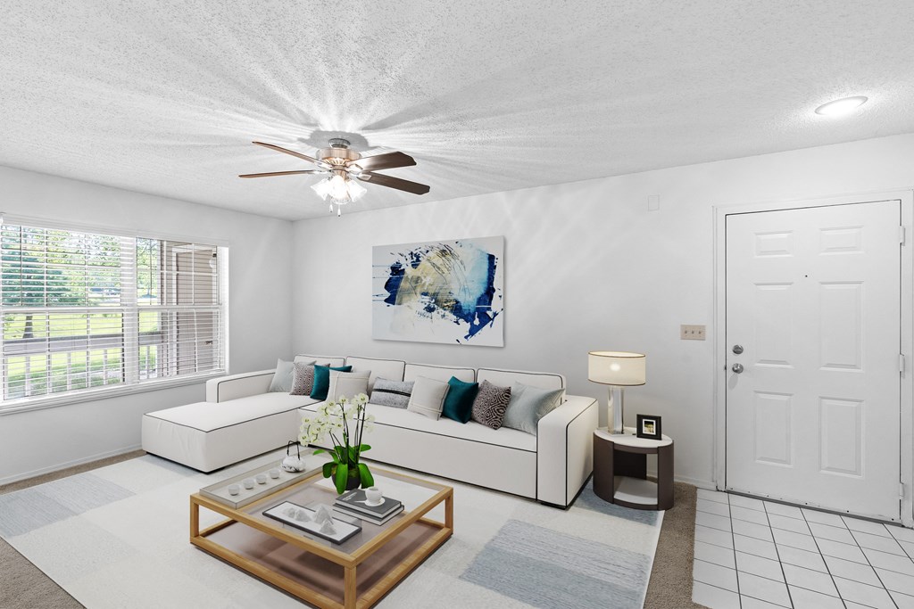 a living room with a white couch and coffee table and a ceiling fanat Stonebriar Apartments, Overland Park, 66213