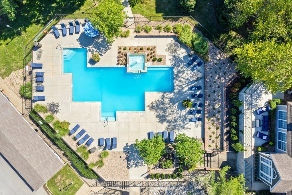 arial view of a swimming pool in a backyard with lounge chairs and treesat Stonebriar Apartments, Overland Park, 66213