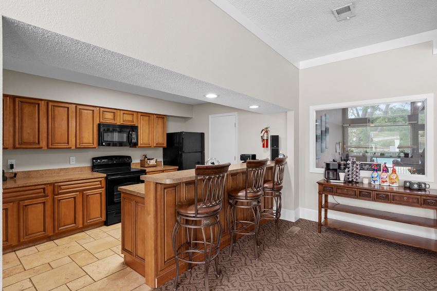 a kitchen with a large island and a breakfast bar a kitchen with a large island and a breakfast bar at Millcreek Woods Apartments, Olathe, Kansas - Photo Gallery