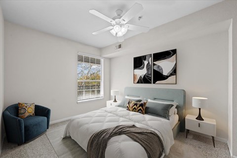 A bedroom with a large bed and a ceiling fan.