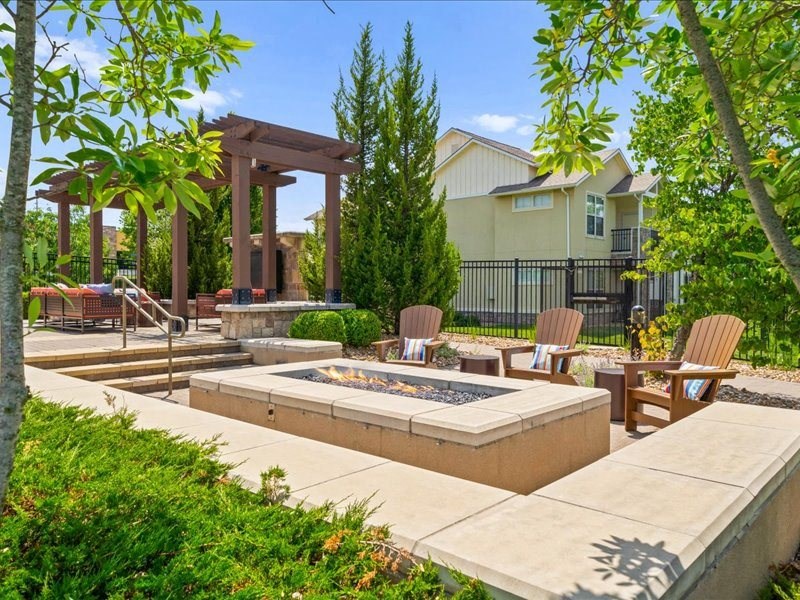 a patio with chairs and a fire pit      and a house