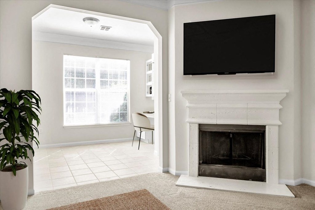 a living room with a fireplace and a tv above it at Wynnewood Farms Apartments, Overland Park, Kansas