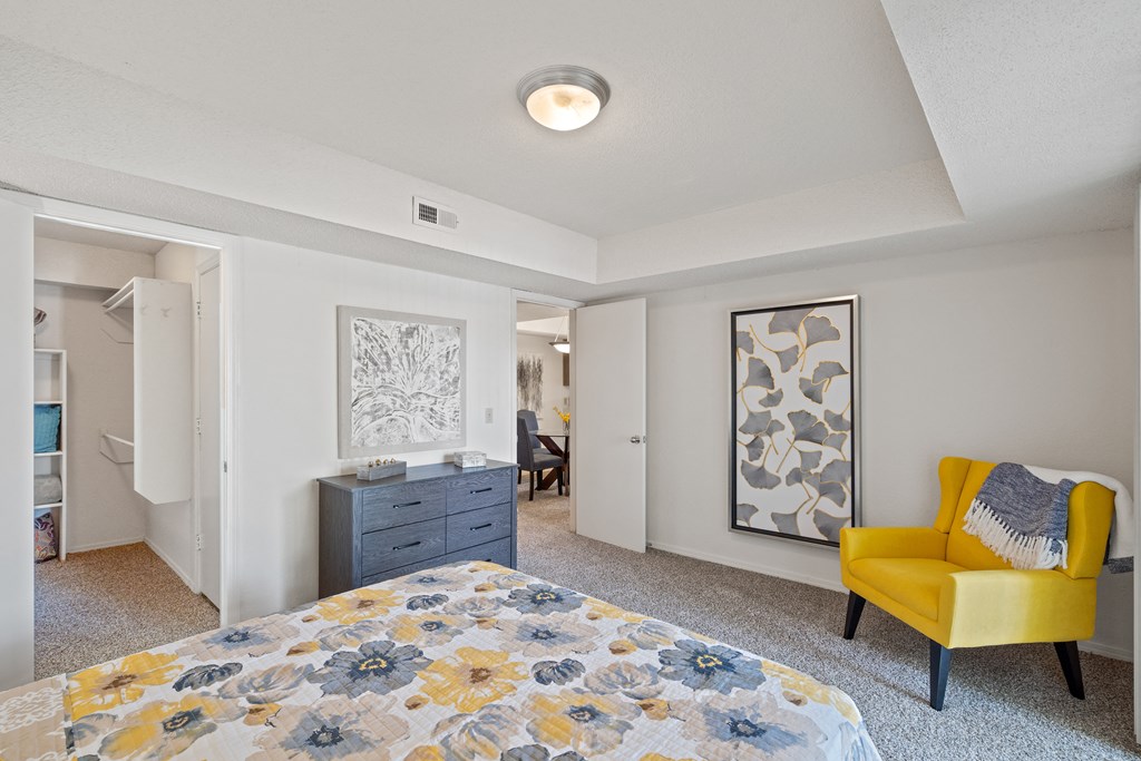 a bedroom with a bed and a dresser at Waterford Place Apartments & Townhomes, Overland Park, KS