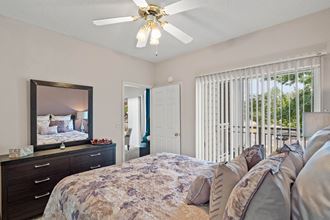 a bedroom with a bed and a ceiling fan  at Claremont, Overland Park, KS