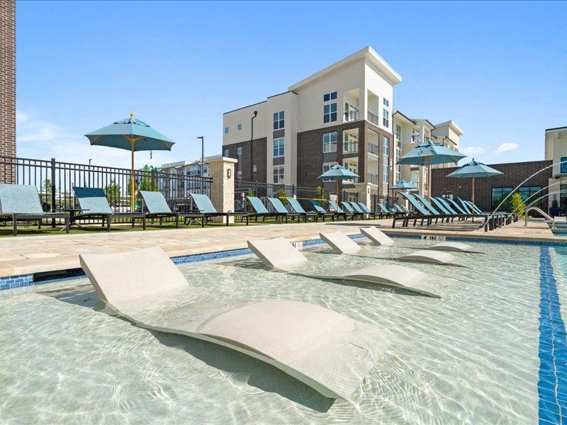 a swimming pool with lounge chairs and umbrellas