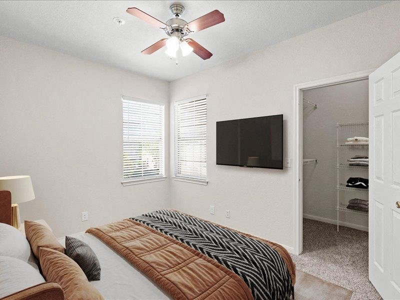 a bedroom with a large bed and a ceiling fan