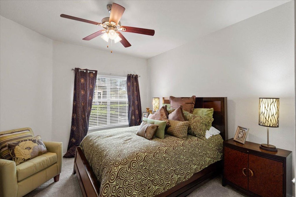 a bedroom with a bed and a ceiling fan