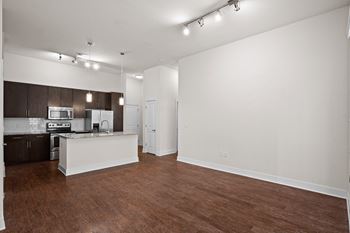 A kitchen with brown floors and white walls.