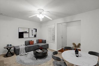 a living room with a round table and a ceiling fan