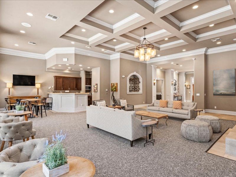a living room with couches and chairs and a kitchen