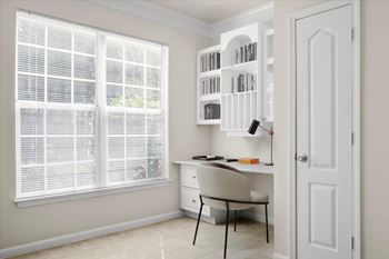 A room with a desk, chair, and bookshelf at Wynnewood Farms Apartments, Overland Park 66209