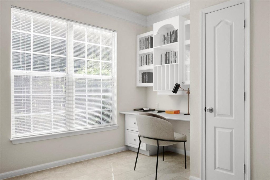 a home office with a desk and a chair in front of a window at Wynnewood Farms Apartments, Overland Park 66209