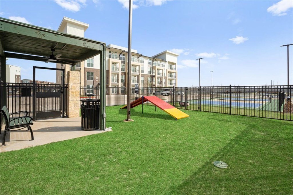 a playground with a seesaw in front of an apartment building