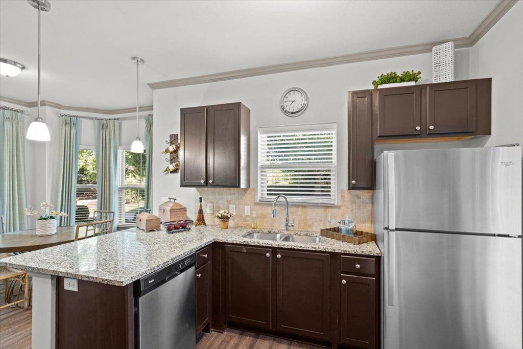 a kitchen with brown cabinets and a granite counter top
