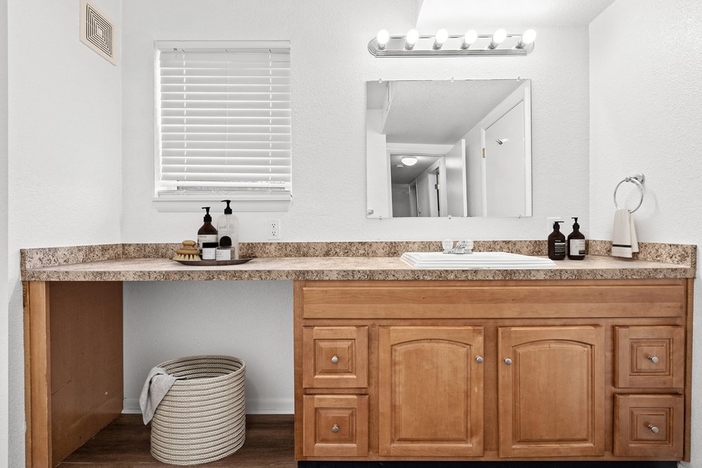 a bathroom with a sink and a mirror at Malvern Hill Apartment Homes, Kansas, 66214