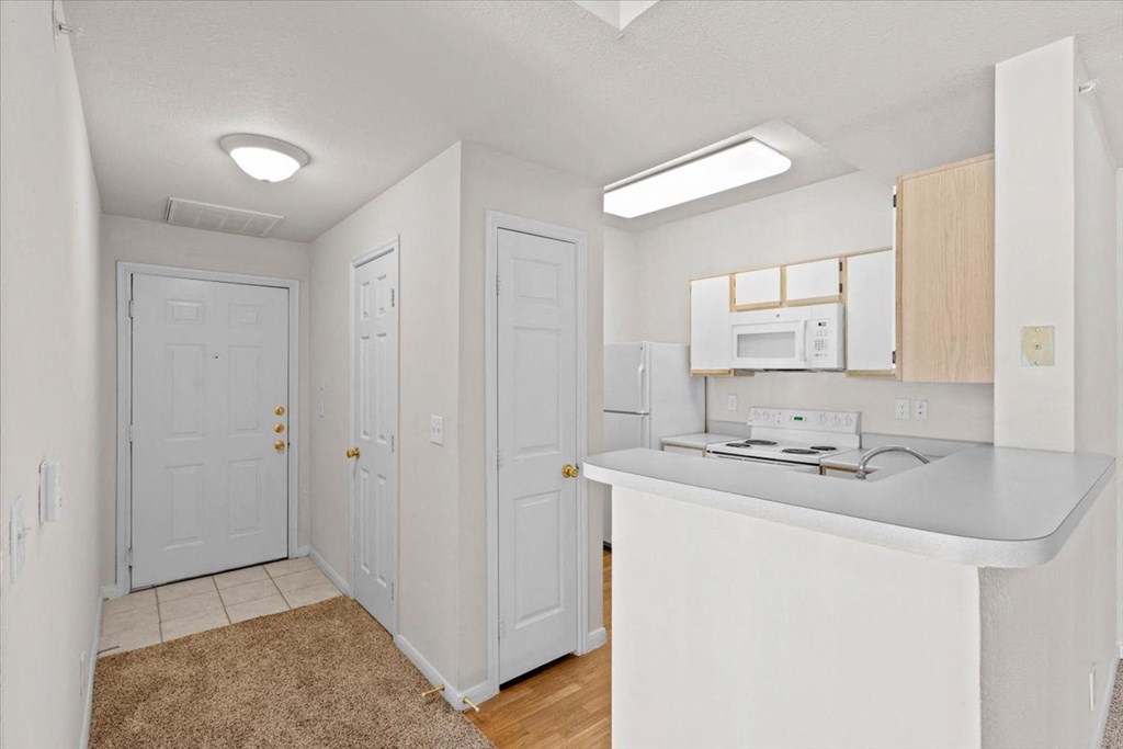 a kitchen with a counter top and a sink and a door  at Crescent, Lenexa, Kansas