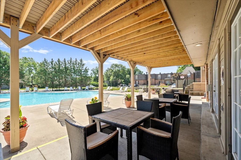 Pool with sitting area with table and chairs  at Louisburg Square Apartments & Townhomes, Overland Park
