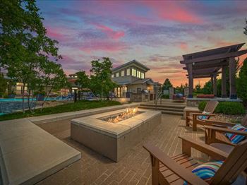 a patio with chairs and a fire pit