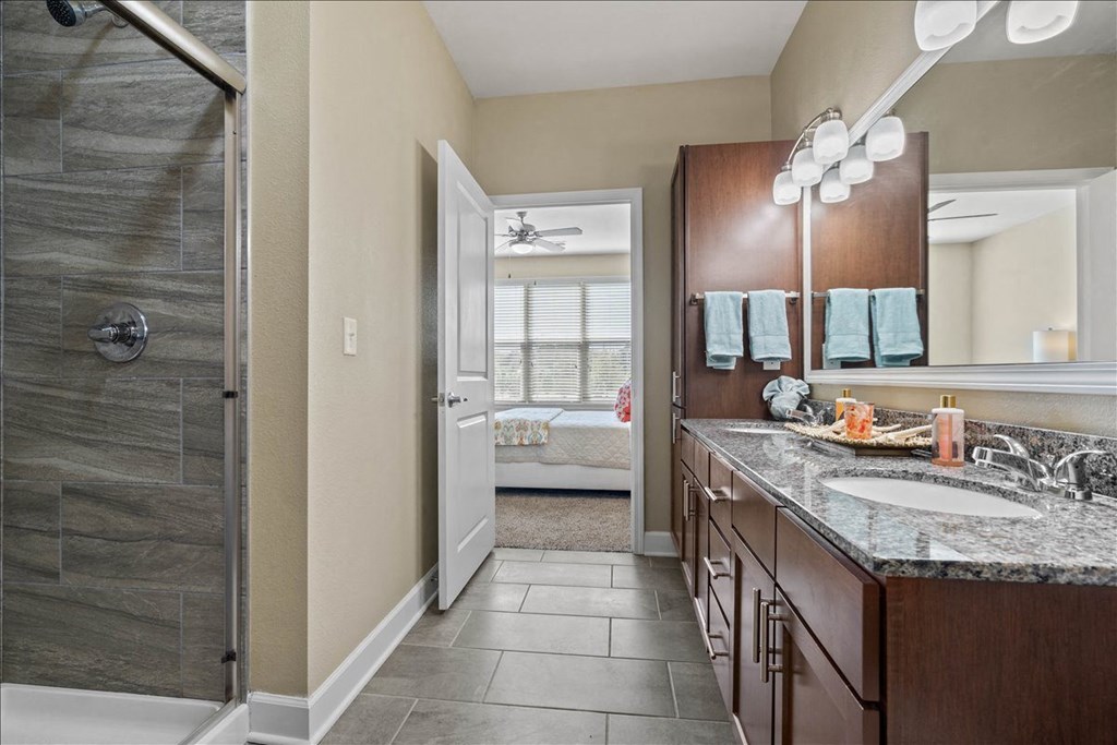 a bathroom with a shower and a sink and a mirror