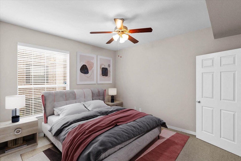 a bedroom with a bed and a ceiling fan at The Clairborne Apartment Homes, Grand Prairie, Texas