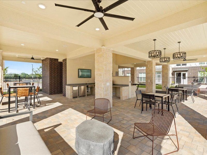 a large patio with tables and chairs and a ceiling fan