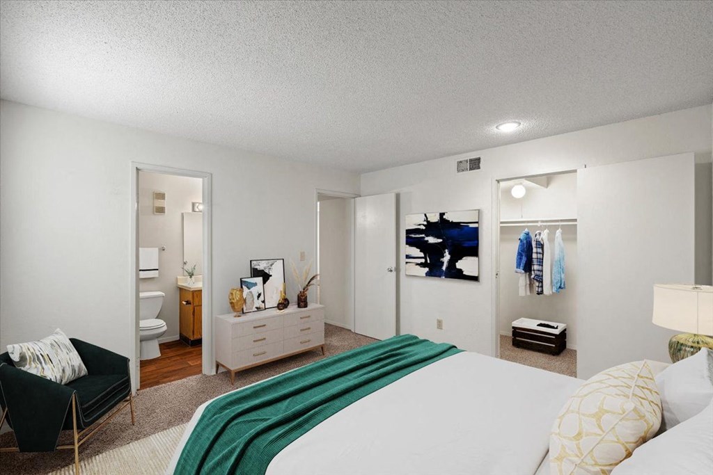 A primary bedroom with a large walk-in closet and an attached bathroom at Bristol Pointe Apartment Homes, Olathe 66062