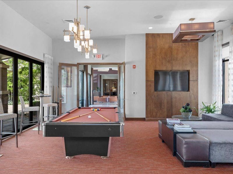 a living room with a pool table and a tv