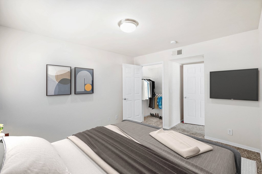 a bedroom with a large bed and a television on the wall a bedroom with a large bed and a television on the wall at Stonebriar Woods, Overland Park