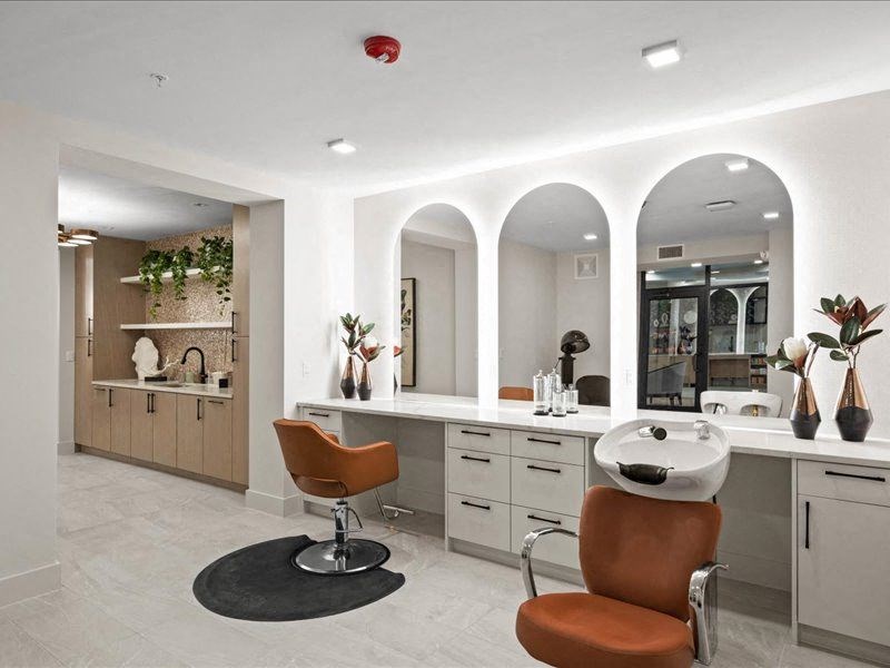 a white salon room with two chairs and a counter