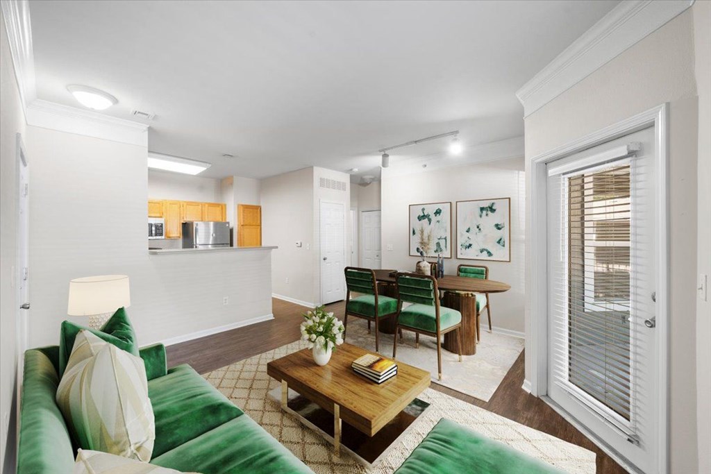 A living room with a green couch and a wooden coffee table. at Somerset Oaks Apartment Homes, Olathe