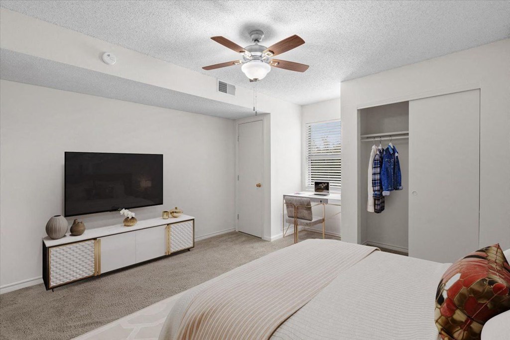 a bedroom with a large bed and a ceiling fan at Wind River Lodge, Lenexa