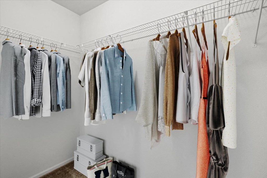 a closet with clothes hanging on a rack