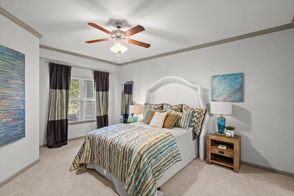 a bedroom with a bed and a ceiling fan