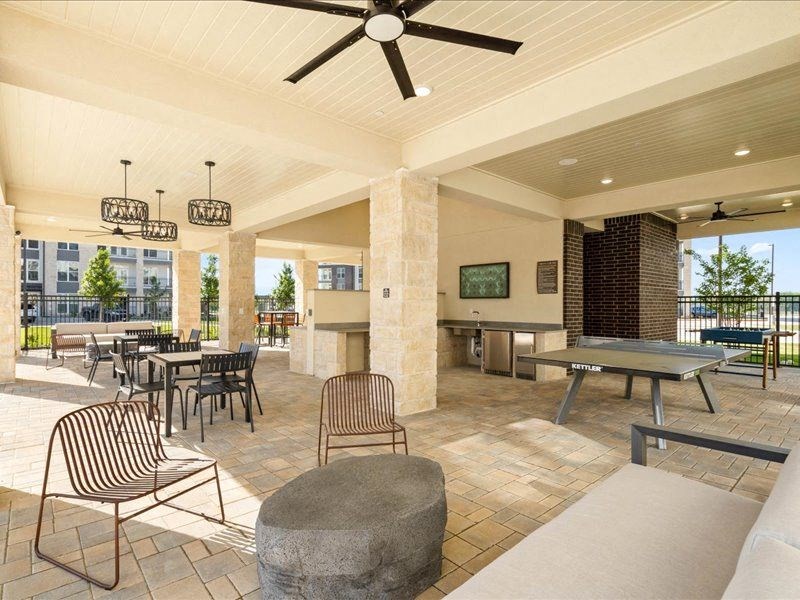 a large patio with tables and chairs and a ceiling fan