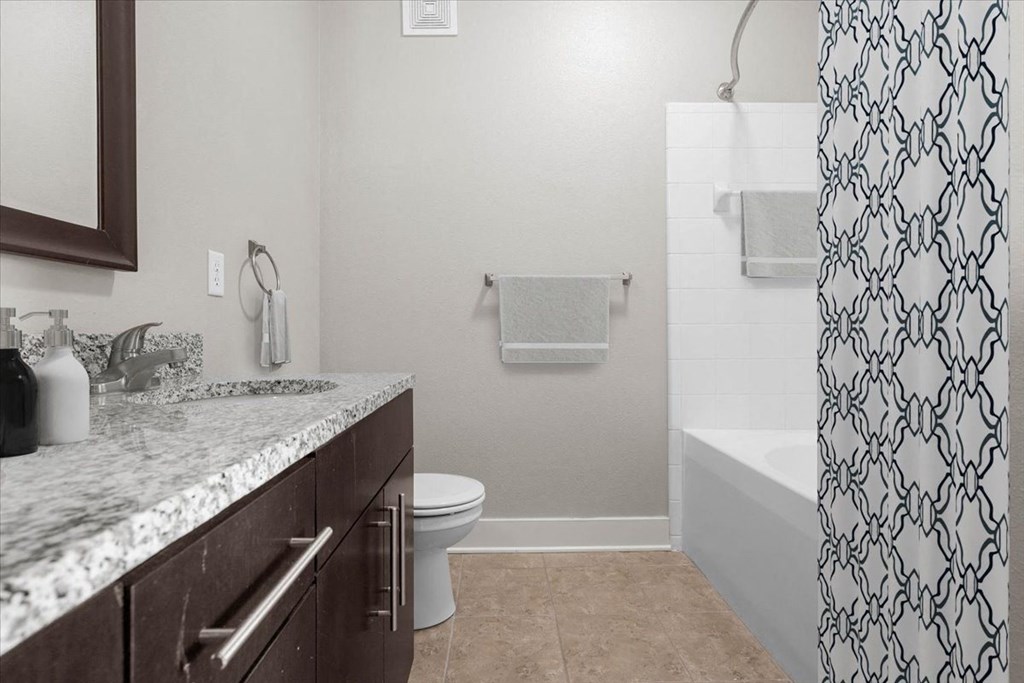 a bathroom with a shower and a sink and a toilet