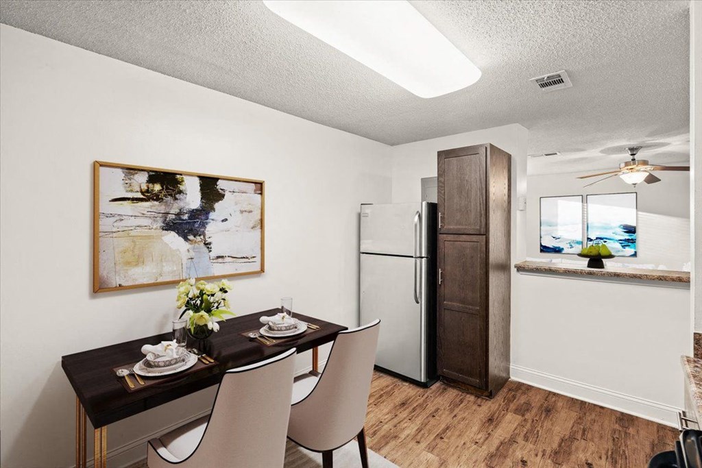 a dining room with a table and chairs and a refrigerator